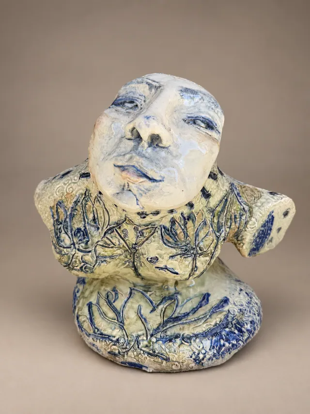 Figure with a pale face and a blue floral body