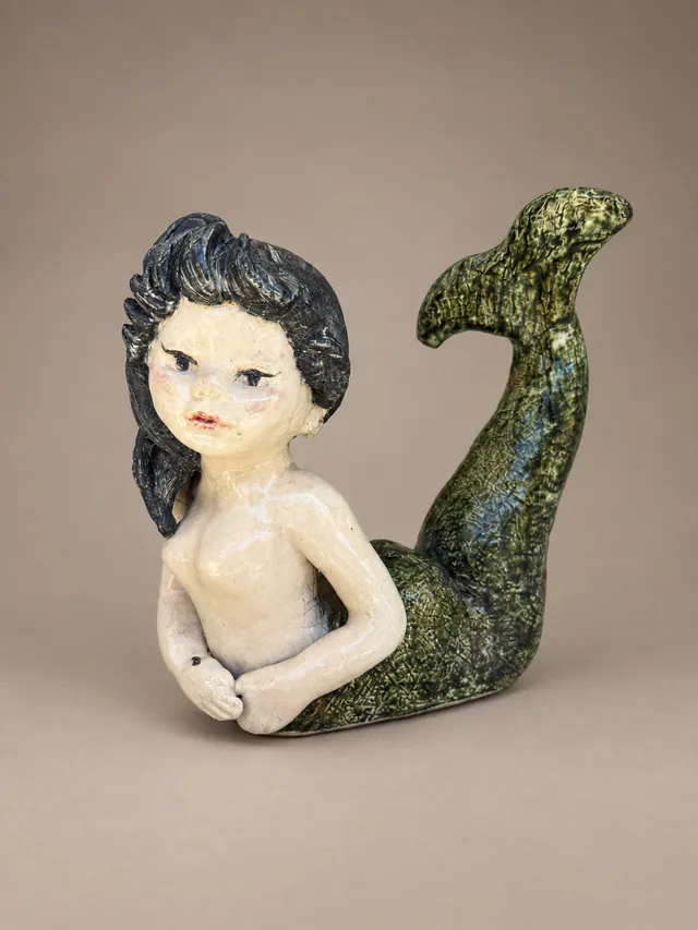 Mermaid figure with a green tail
