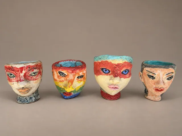 Four face cups with painted masks
