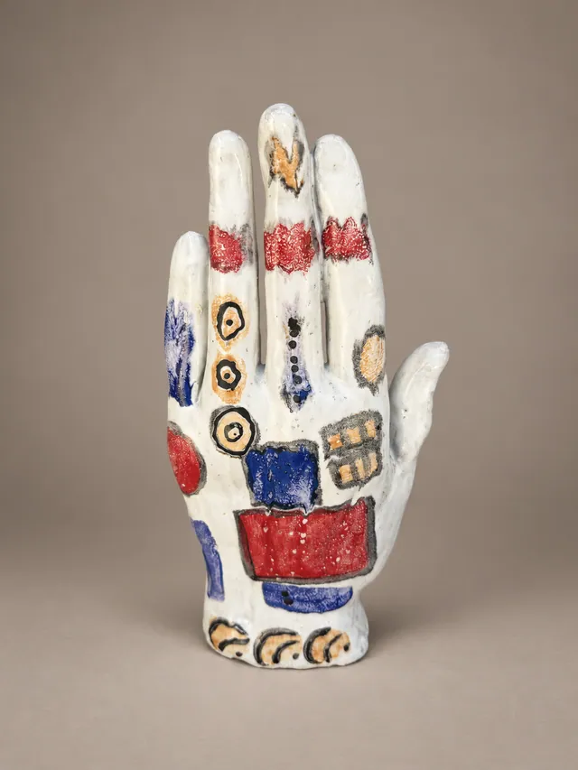 White hand painted with red, blue and gold symbols